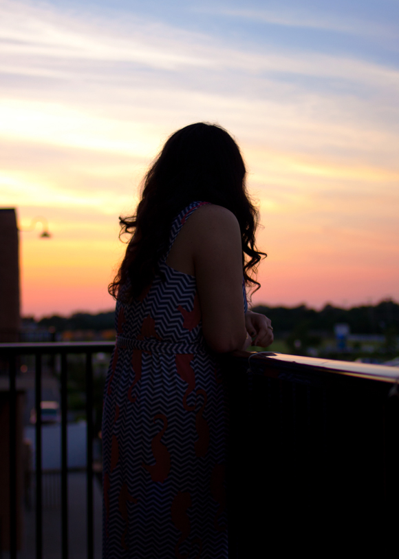 fashion blogger wearing tracy negoshian rihanna maxi dress on a balcony at sunset