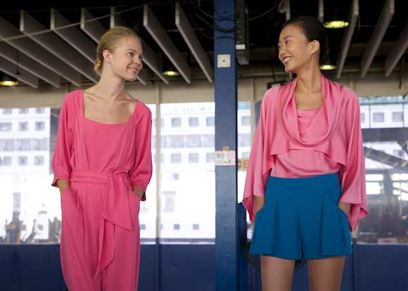 Models smile at each other at Catherine Malandrino Spring 2014 looks in pink and blue at New York Fashion Week