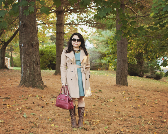 fashion blogger outfit of club monaco trench coat, reiss leather dress, frye boots, coach satchel photographed while standing in the woods