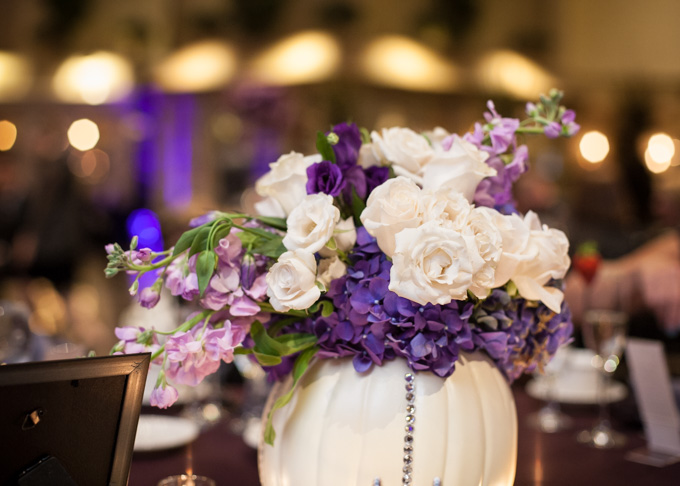 fall wedding pumpkin centerpiece with purple and white flowers