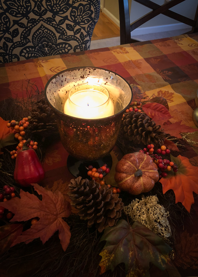 Thanksgiving table decor with leaves and pumpkins.
